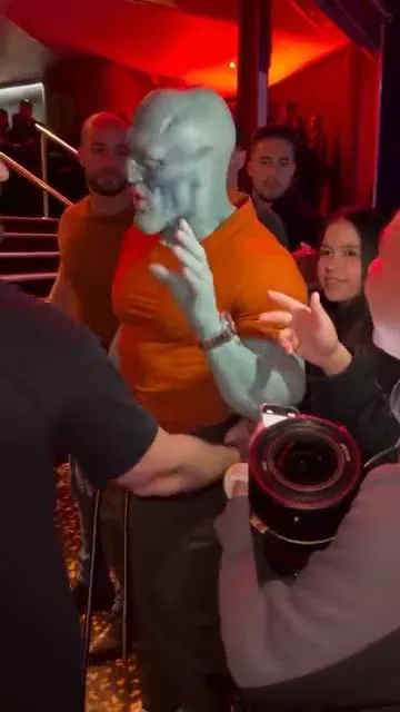 Reference remix showing a skeletal character in an orange shirt performing beside the crowd.